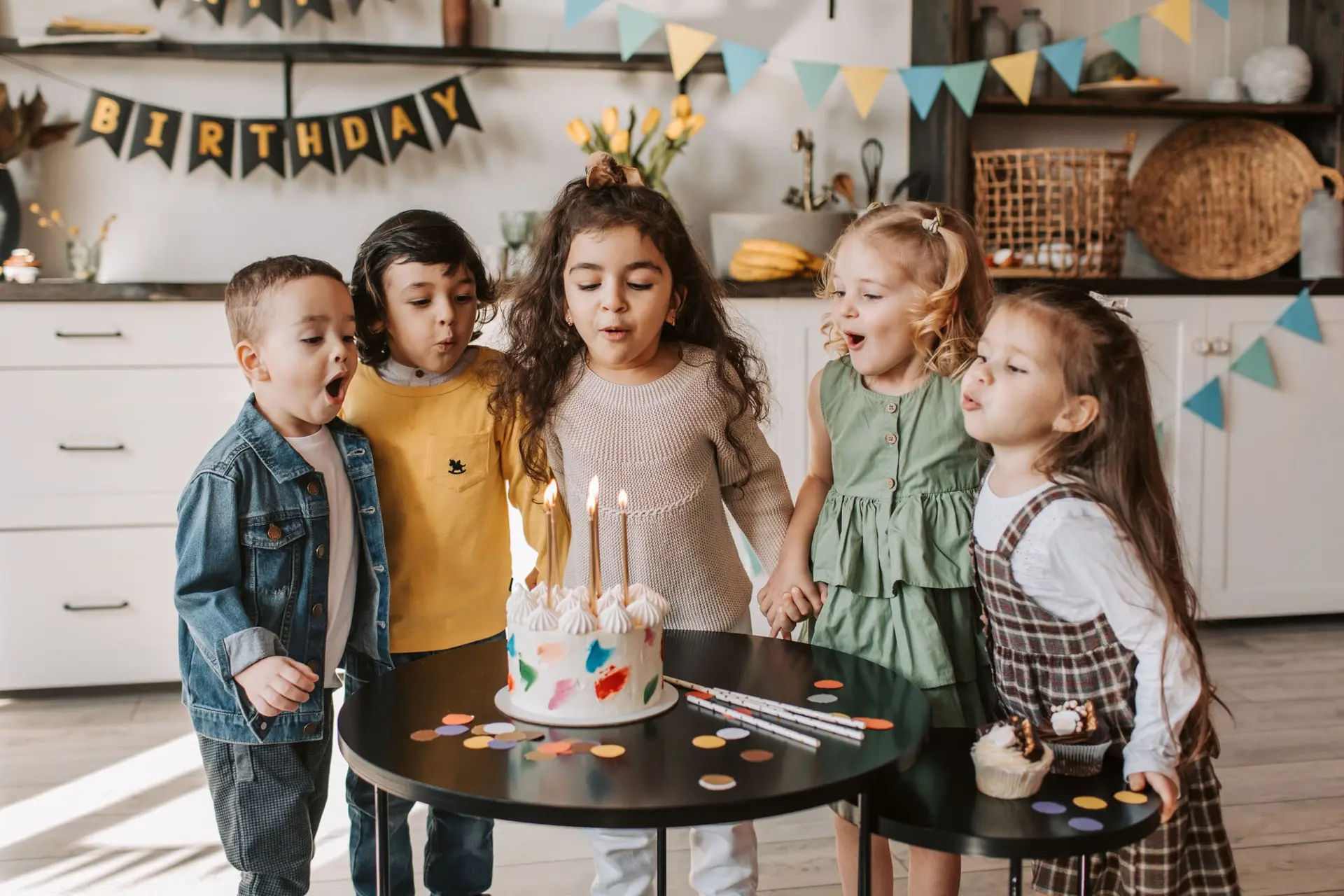 Crianças soprando as velas do bolo de aniversário (imagem de referência)