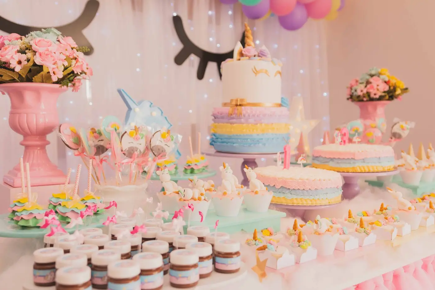 Mesa de doces e bolo em festa infantil colorida (imagem de referência)
